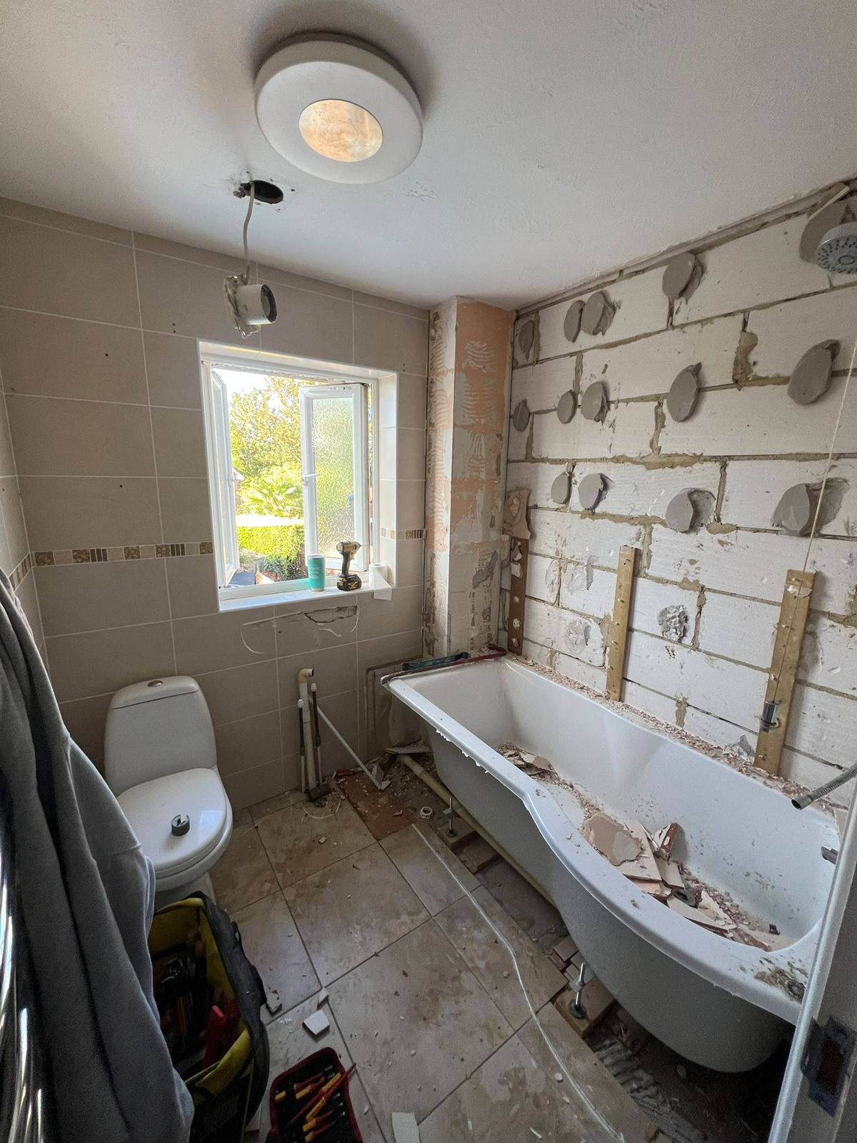 Bathroom stripped out with old tiles and plaster hacked off the walls